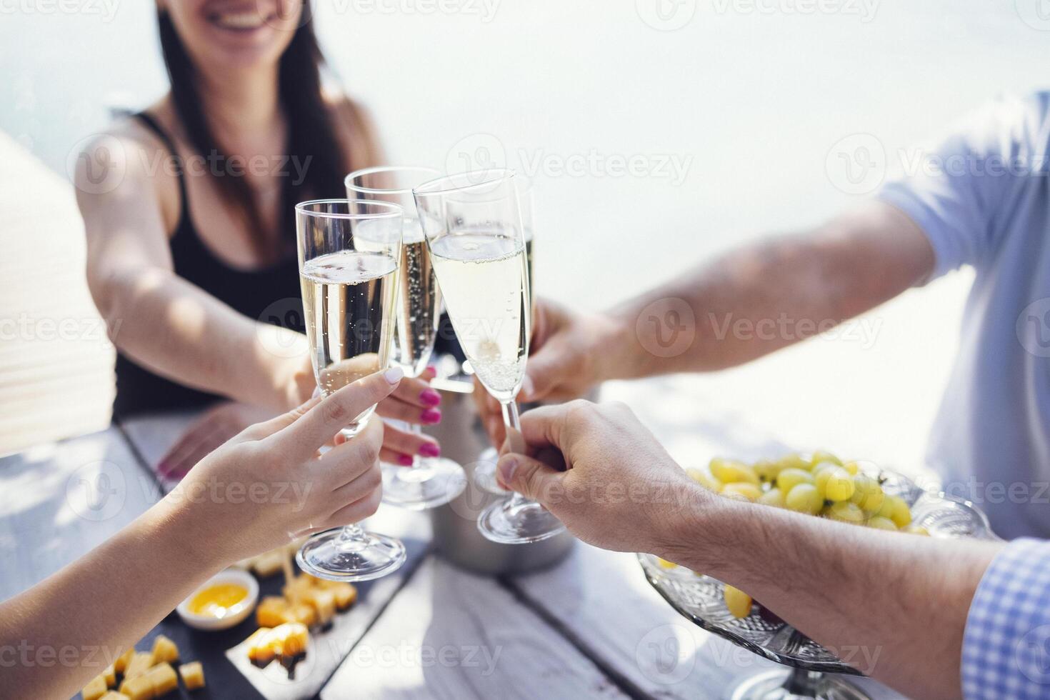 Happy people on the beach having a party, drinking and having a lot of fun in the sunse photo