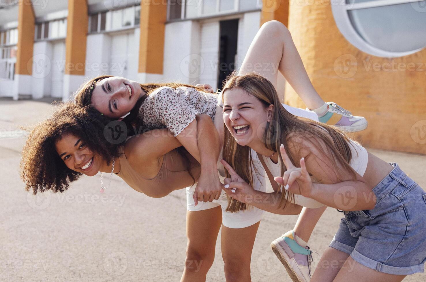 Three multiracial female teenagers huging and having fun together. photo
