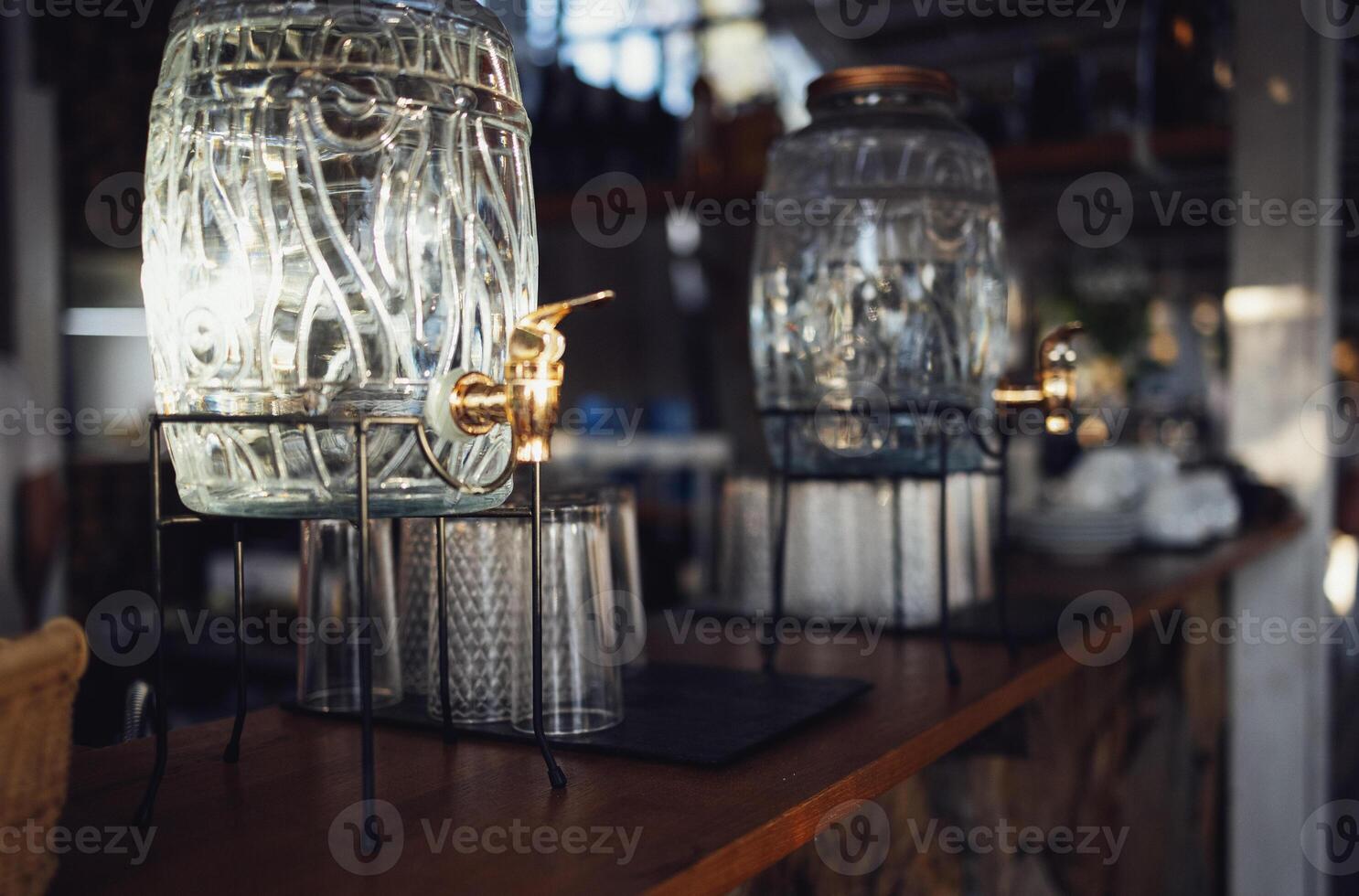 Two glass dispensers with metal tap and a lid photo