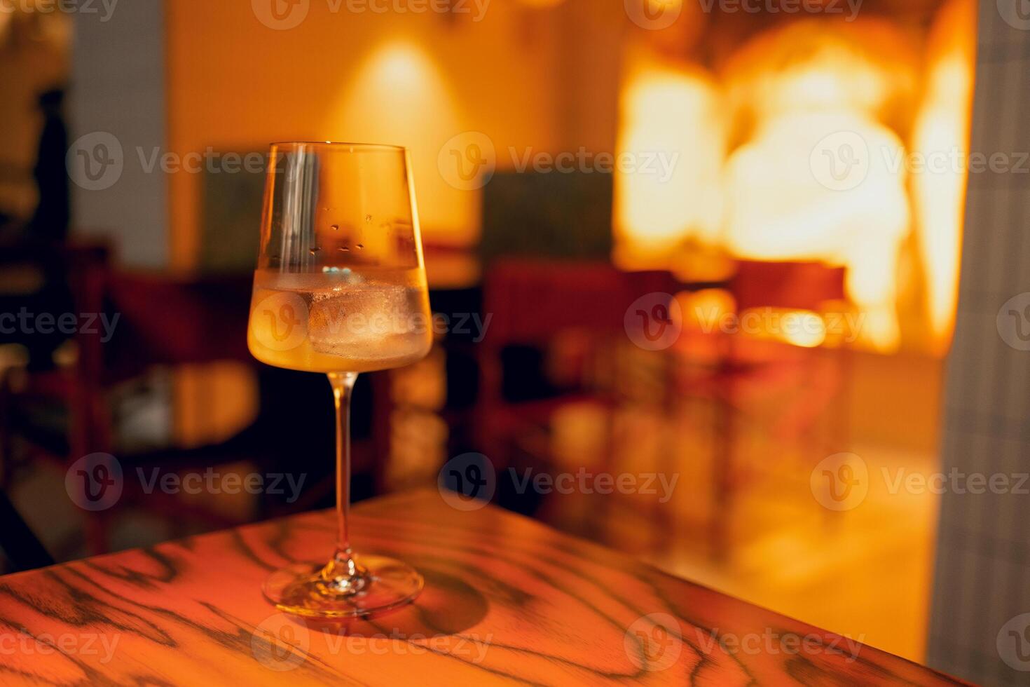 One delicious ice cold cocktail in exquisite glasses stand on a wooden table in a restaurant. photo