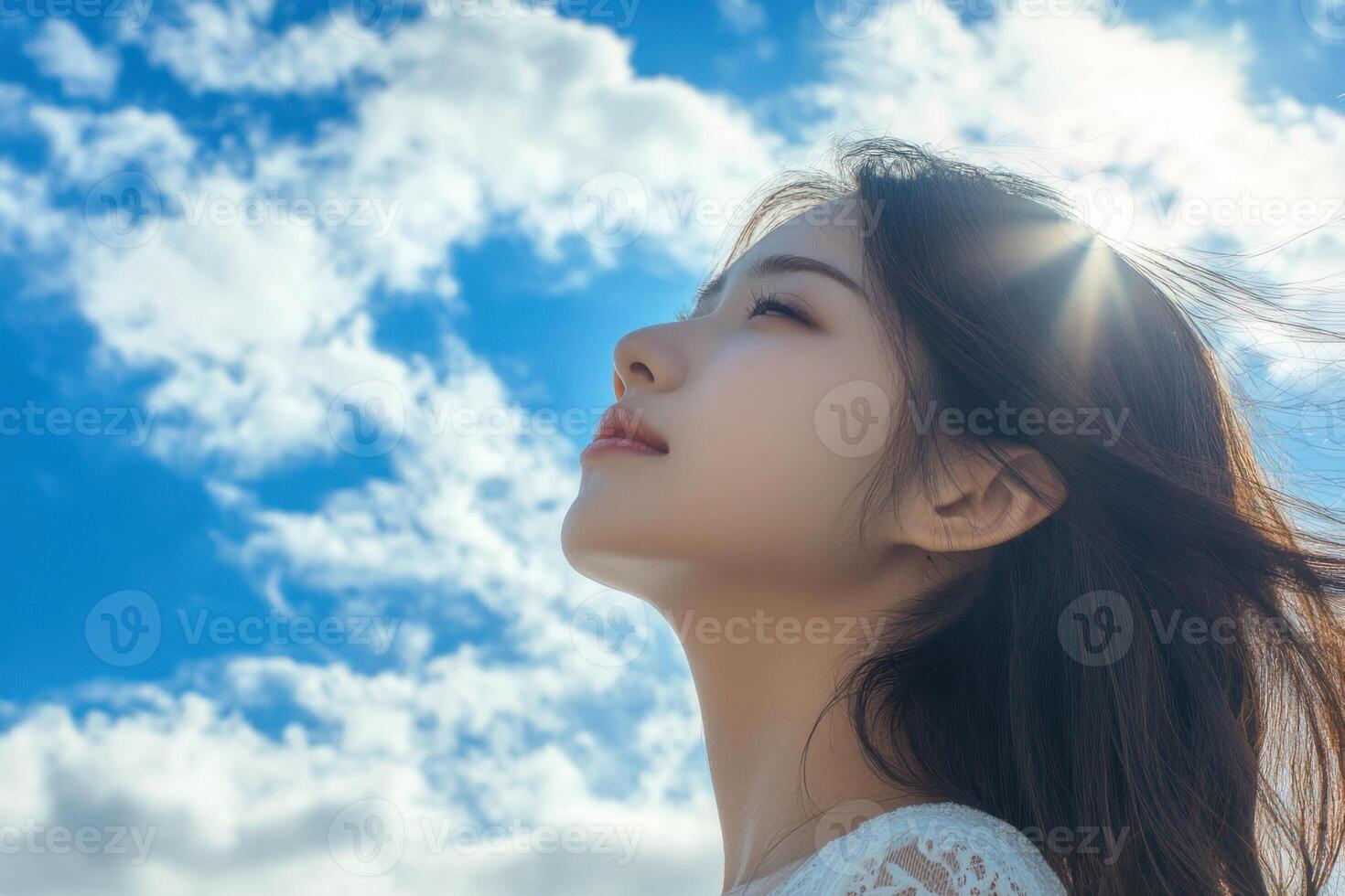 Beautiful woman smiling hair blowing in the wind blue sky background. photo