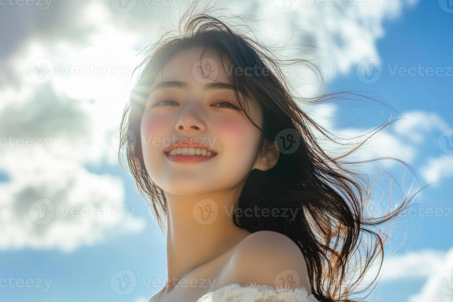 Beautiful woman smiling hair blowing in the wind blue sky background. photo