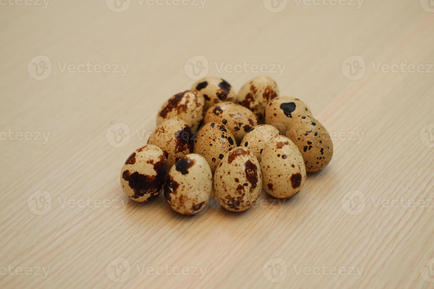 Quail eggs on a wooden background. Close-up, selective focus. photo