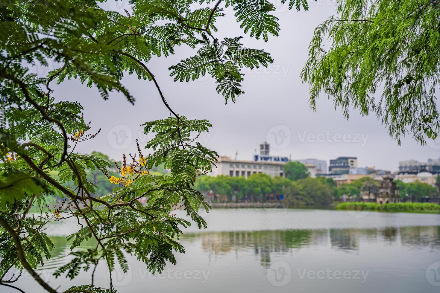 Hoan Kiem lake or Sword lake, Ho Guom in Hanoi, Vietnam with Turtle Tower, on clear day with blue sky and white clouds photo