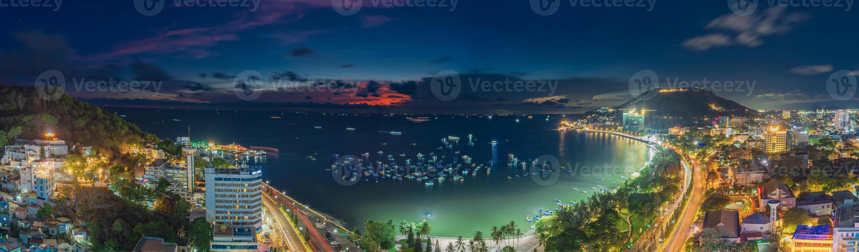 Top view with beautiful sunset and boats. Panoramic view of Vung Tau coast from above with waves, beach, streets, coconut trees and Tao Phung mountain in Vietnam photo