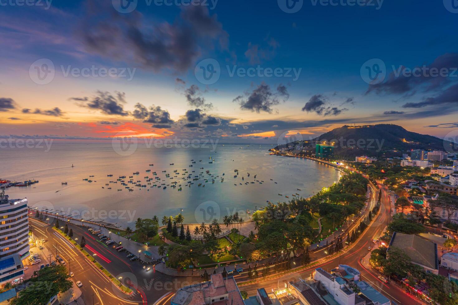 Top view with beautiful sunset and boats. Panoramic view of Vung Tau coast from above with waves, beach, streets, coconut trees and Tao Phung mountain in Vietnam photo