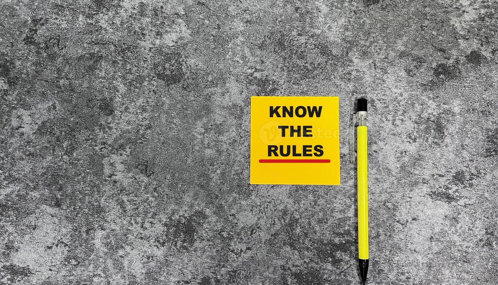 Concept of Know The Rules write on sticky notes isolated on Wooden Table. photo