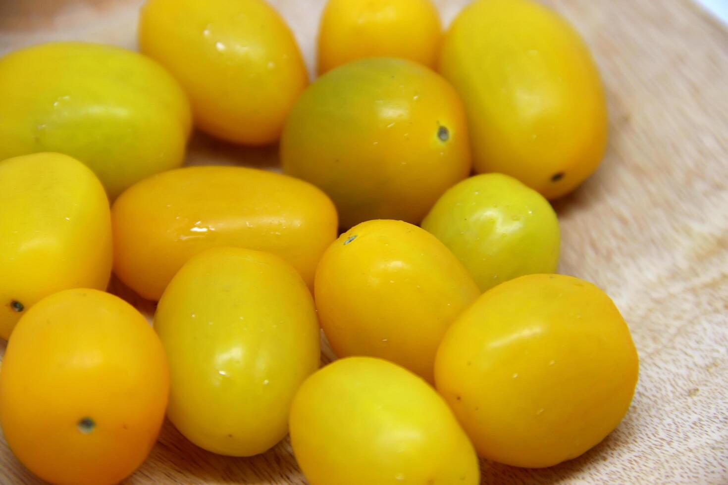 red and yellow cherry tomatoes on wooden plate, tomato, selective focus. tomato background. photo
