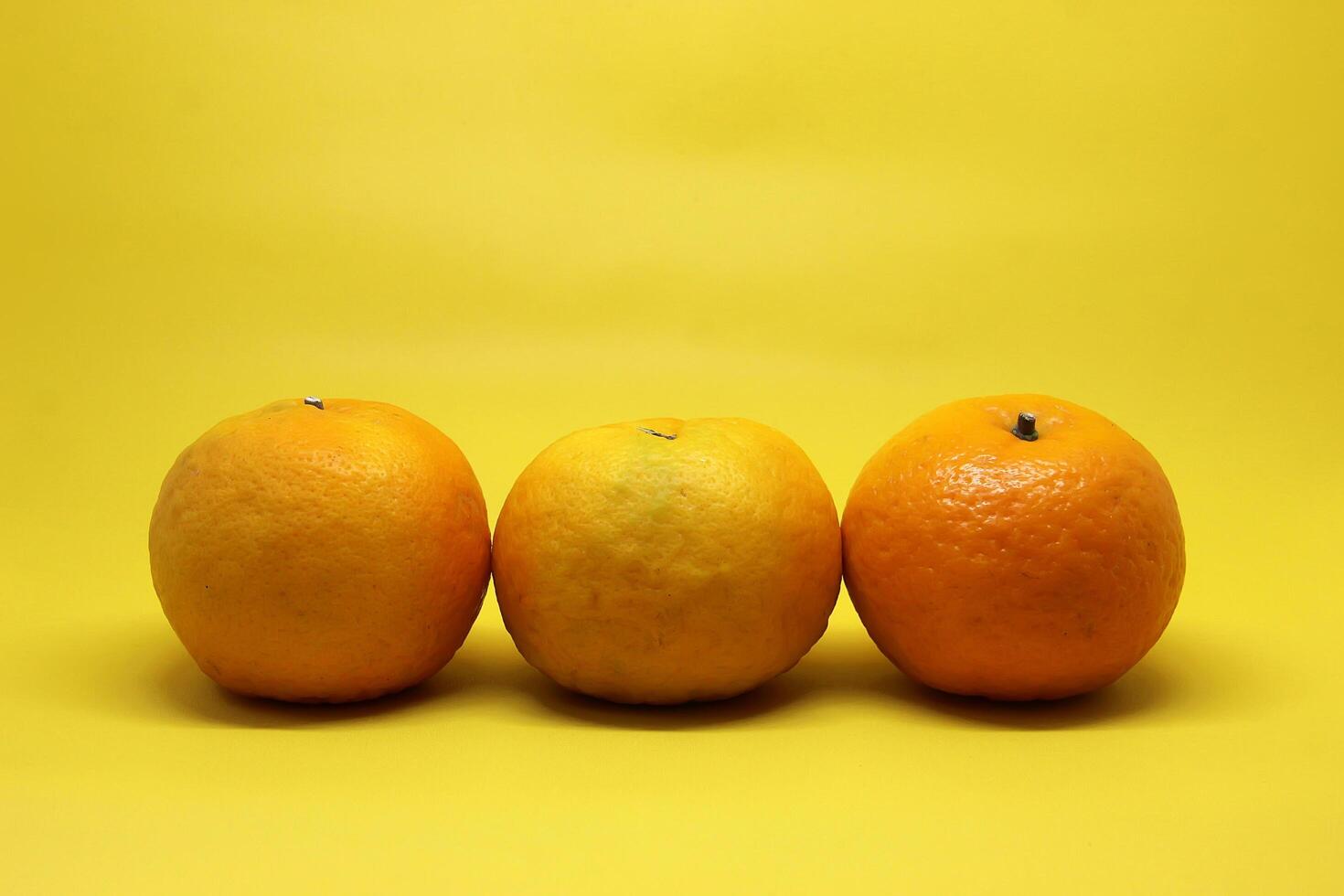Orange Fruit and mango fruit on a Yellow table. photo