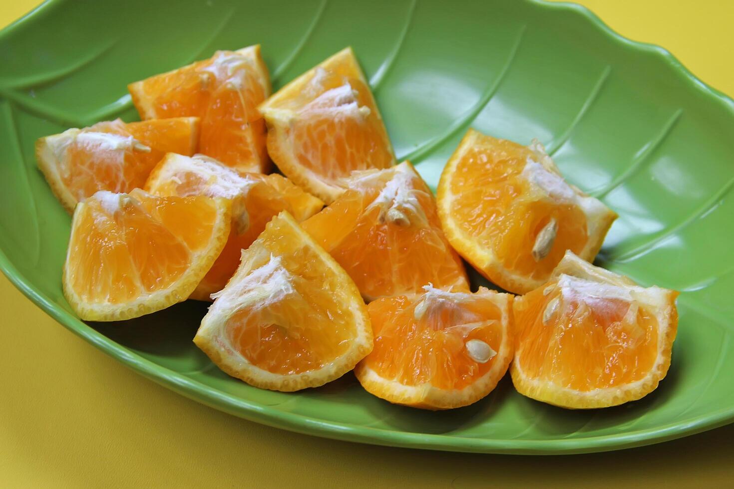 Sliced juicy orange fruit on yellow photo