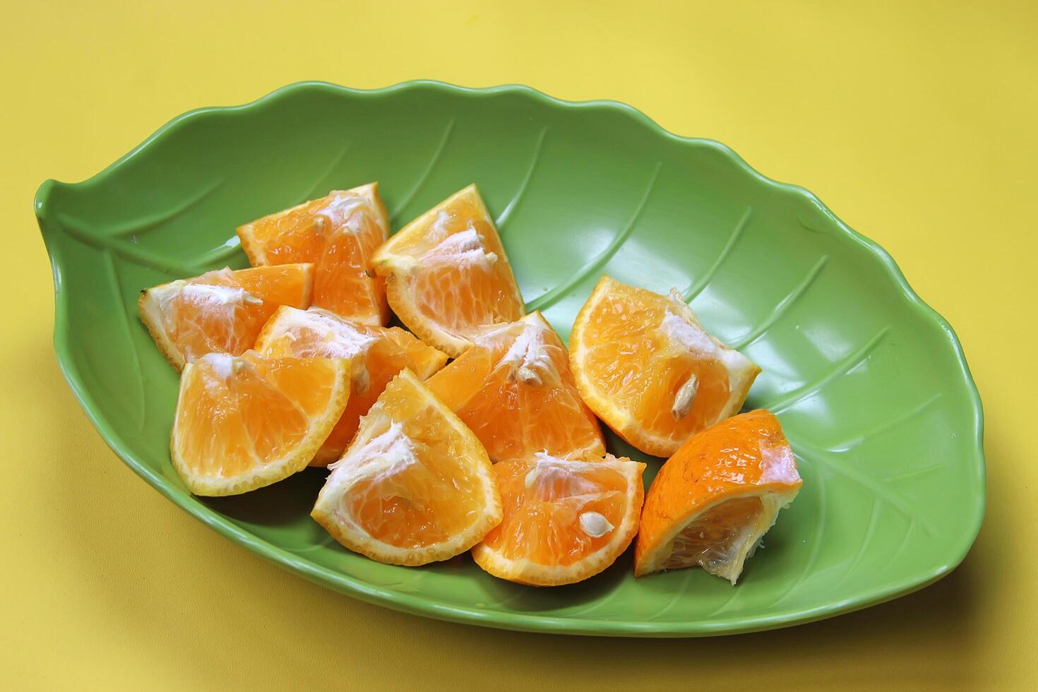 Sliced juicy orange fruit on yellow photo