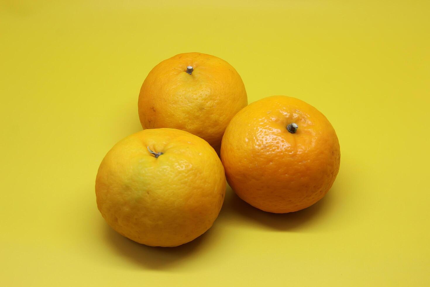 Orange Fruit and mango fruit on a Yellow table. photo