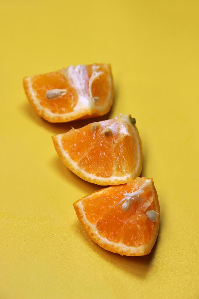 Sliced juicy orange fruit on yellow photo