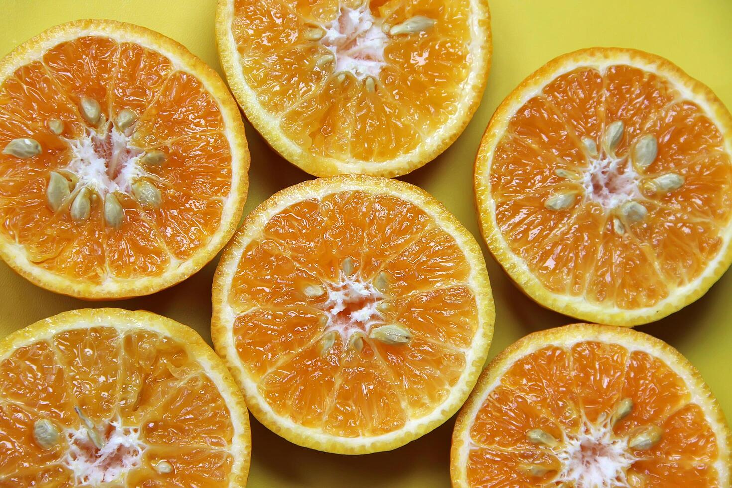 Sliced juicy orange fruit on yellow photo