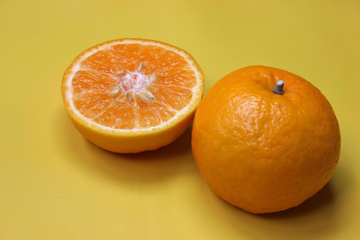 Sliced juicy orange fruit on yellow photo