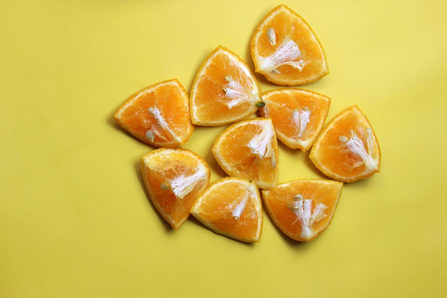 Sliced juicy orange fruit on yellow photo