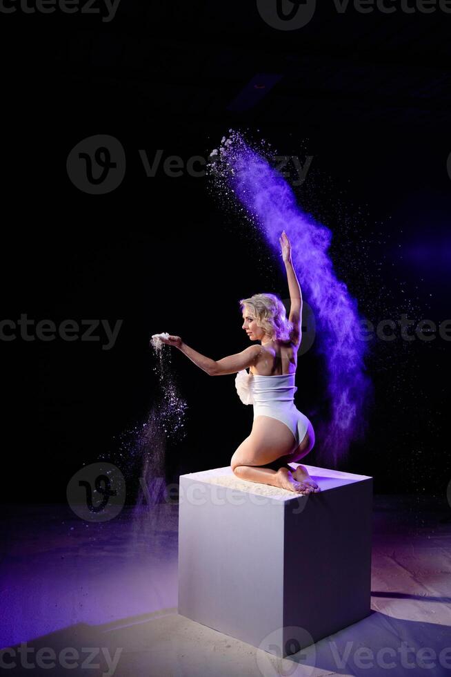 Woman posing with purple particles sprayed in air photo