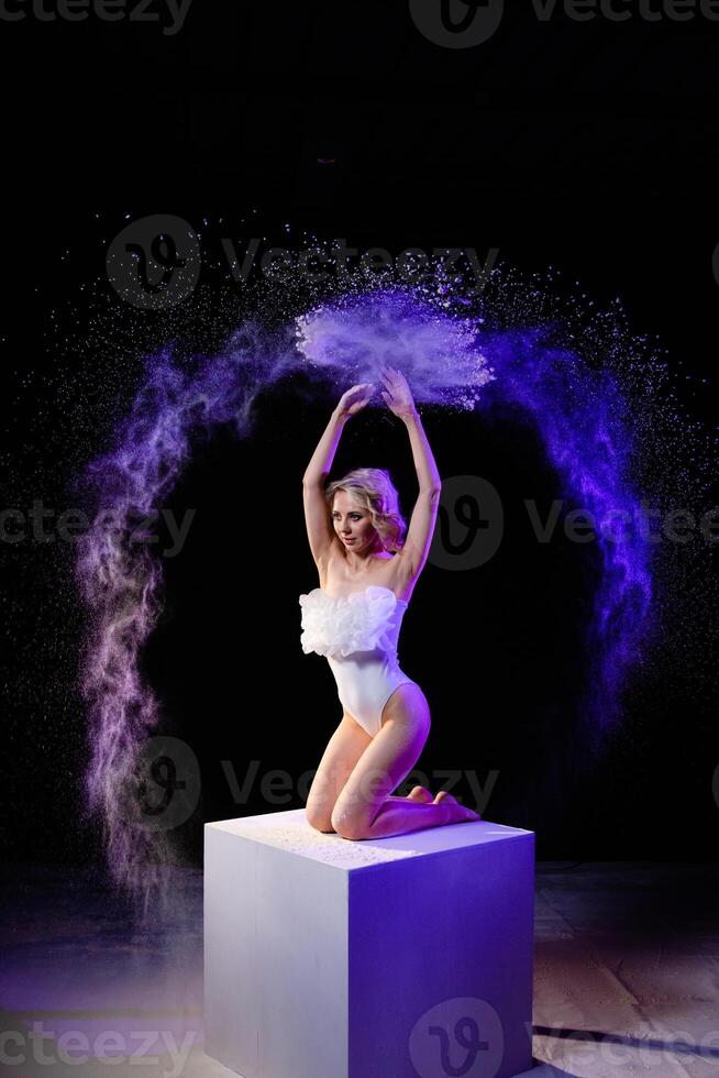 Woman posing with purple particles sprayed in air photo