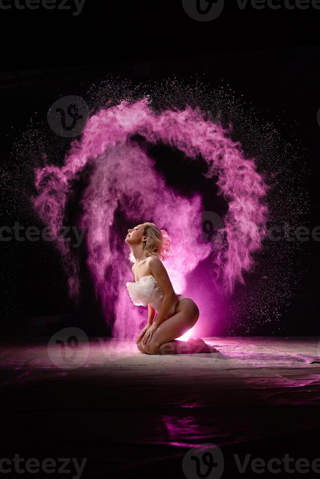 Woman posing with pink particles sprayed in air photo