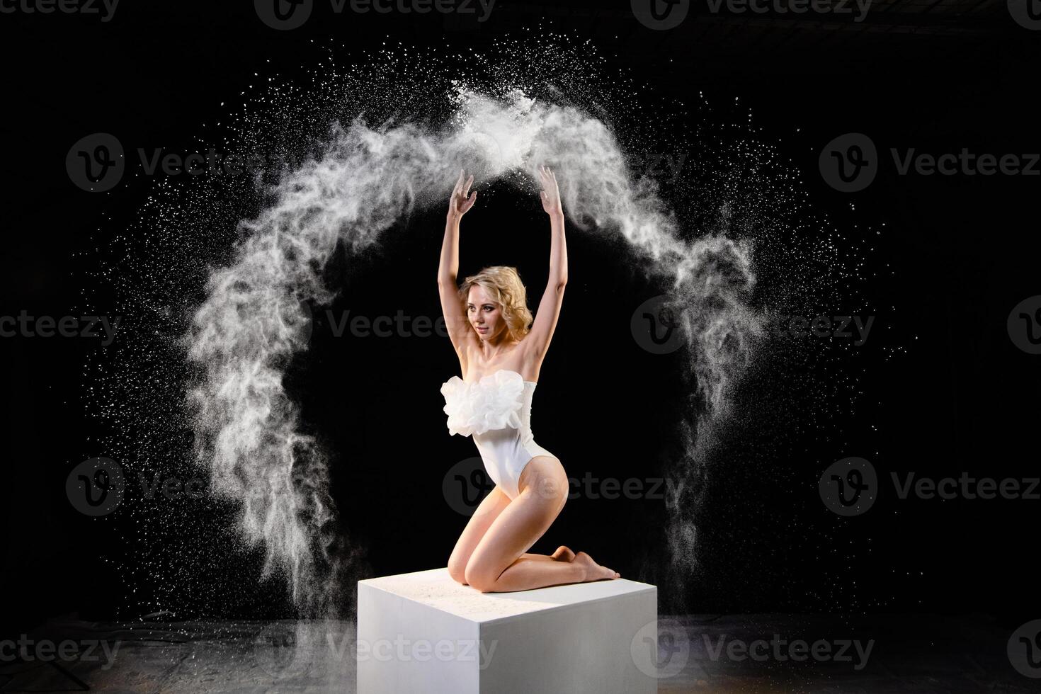 Young slim woman with spread flour on the air photo