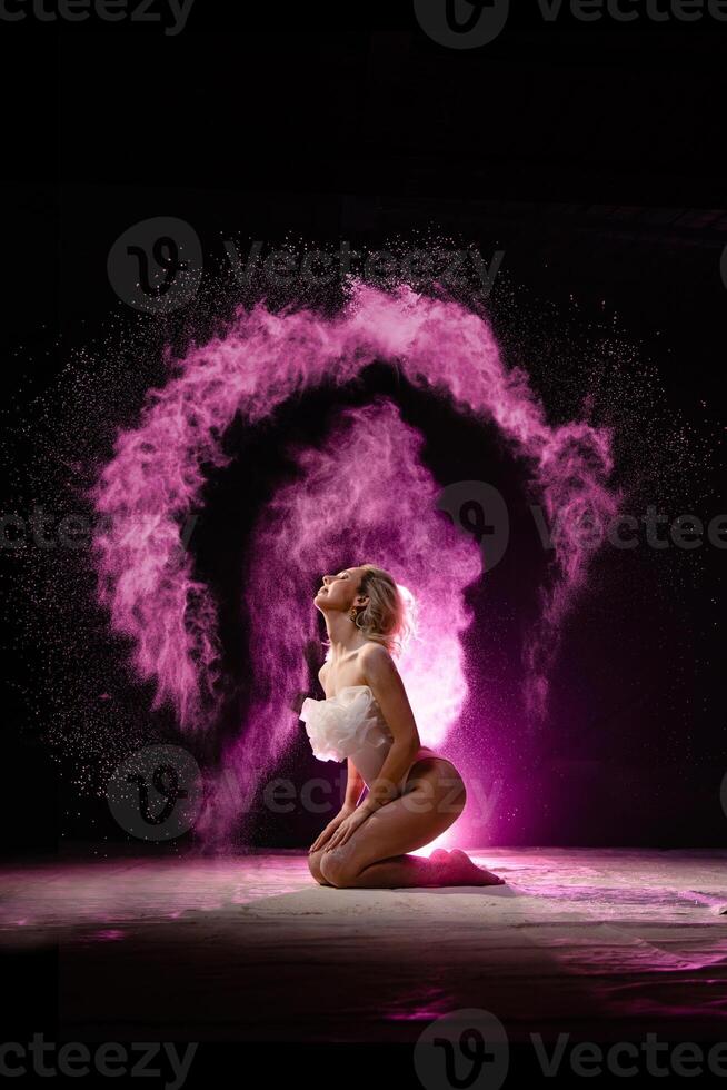 Woman posing with pink particles sprayed in air photo