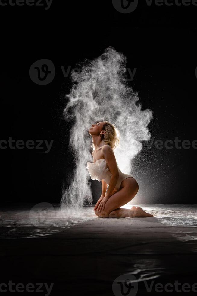 Young slim woman with spread flour on the air photo