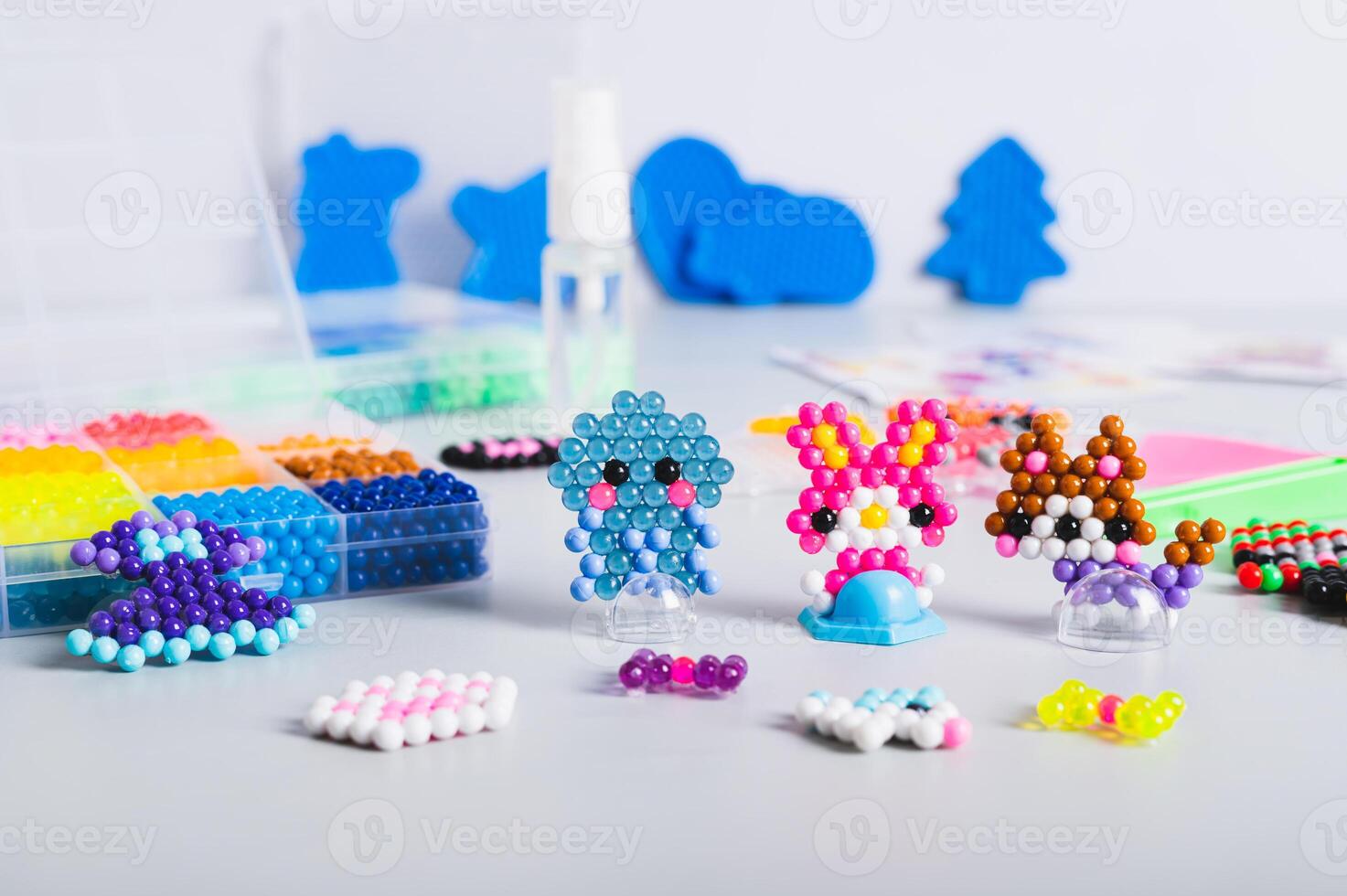 Children's toys made of aqua beads and a set for making on the table photo
