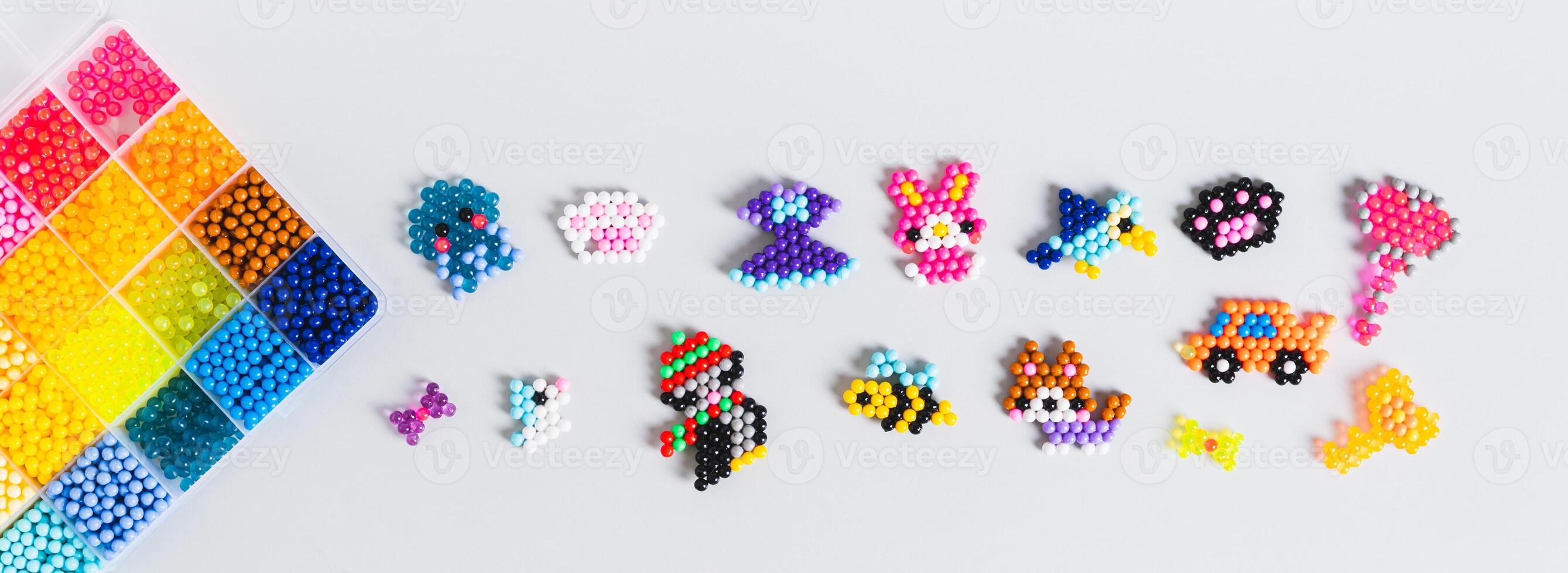 Cute toys and decor made of colorful aqua beads top view web banner photo