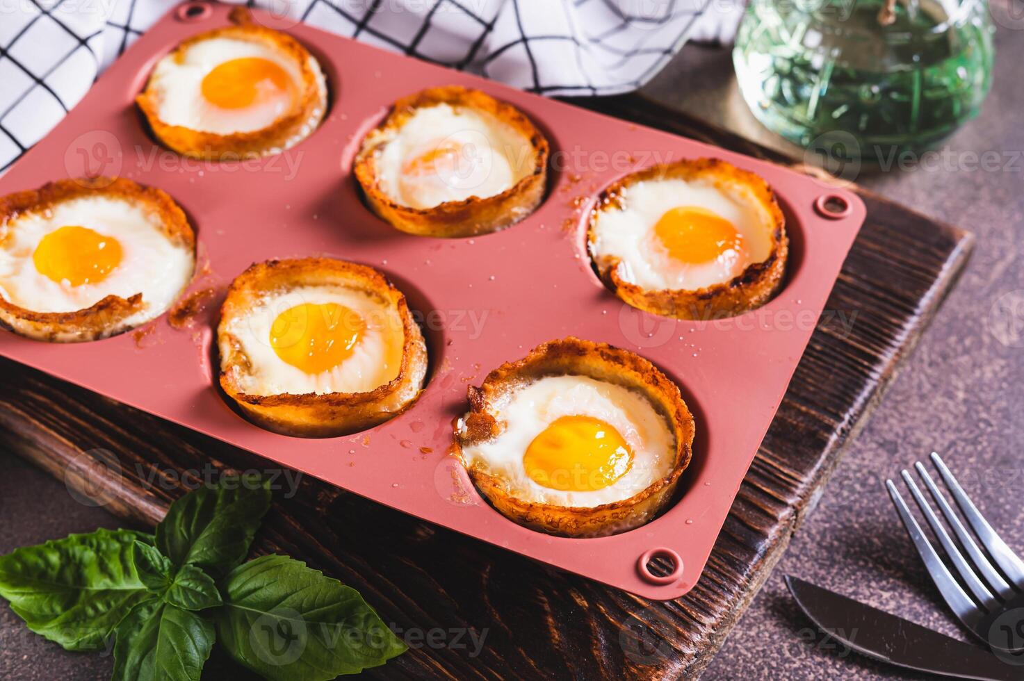 Chicken eggs baked in bacon in a baking dish on the table photo