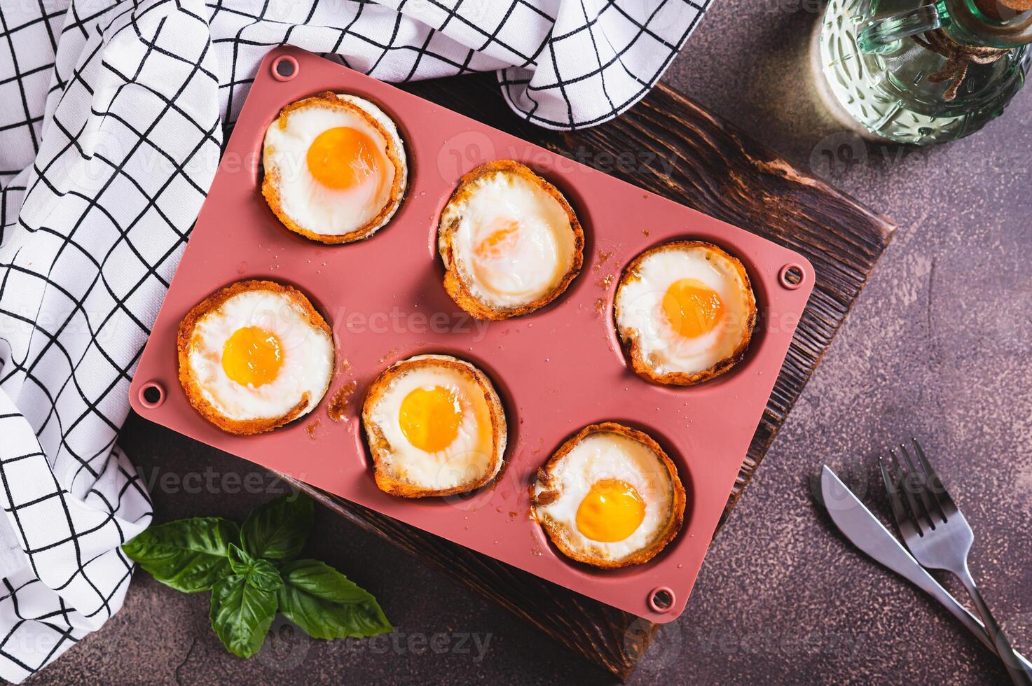 Chicken eggs baked in bacon in a baking dish on the table top view photo