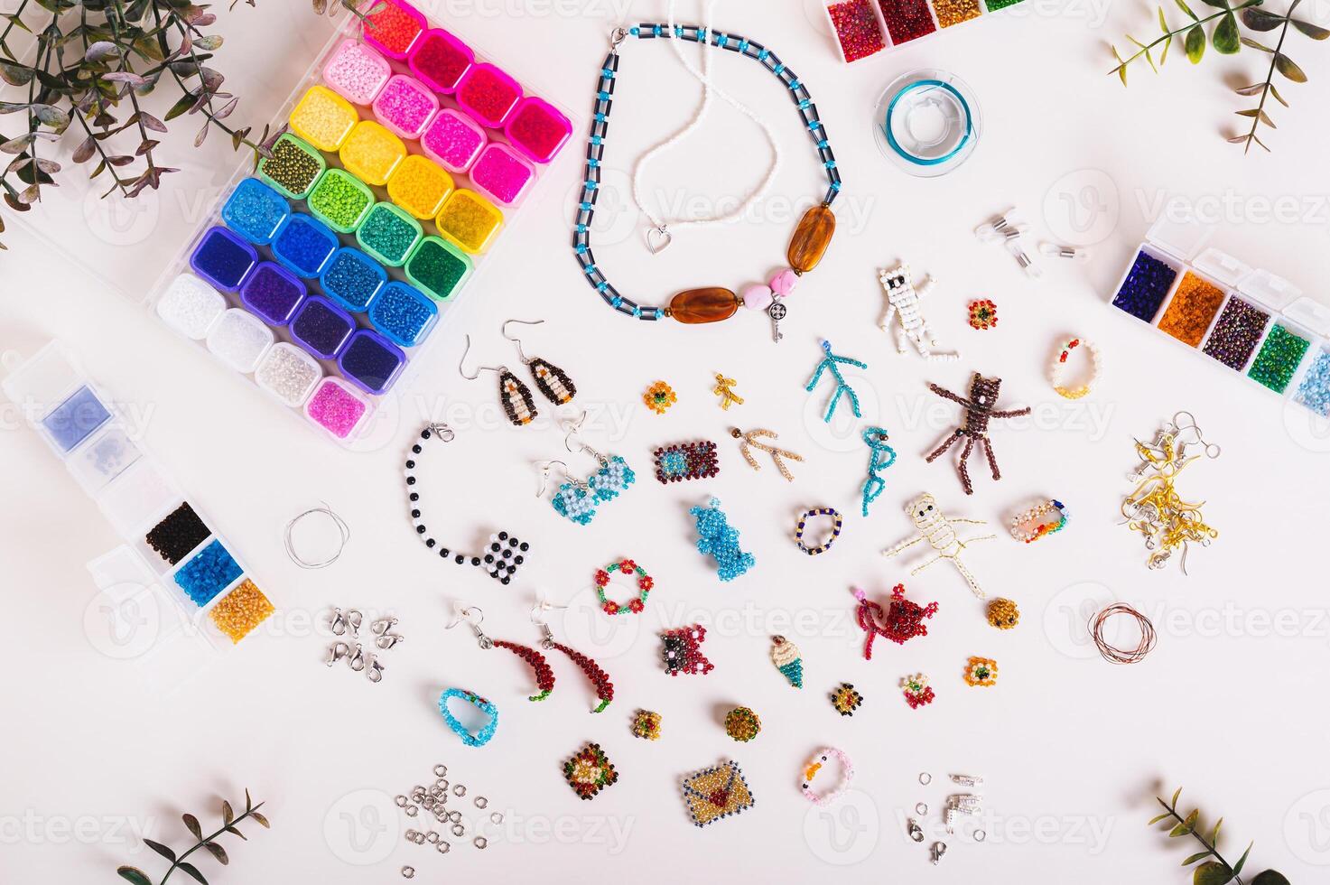 Various beaded jewelry and toys and boxes with colorful beads on the table top view photo