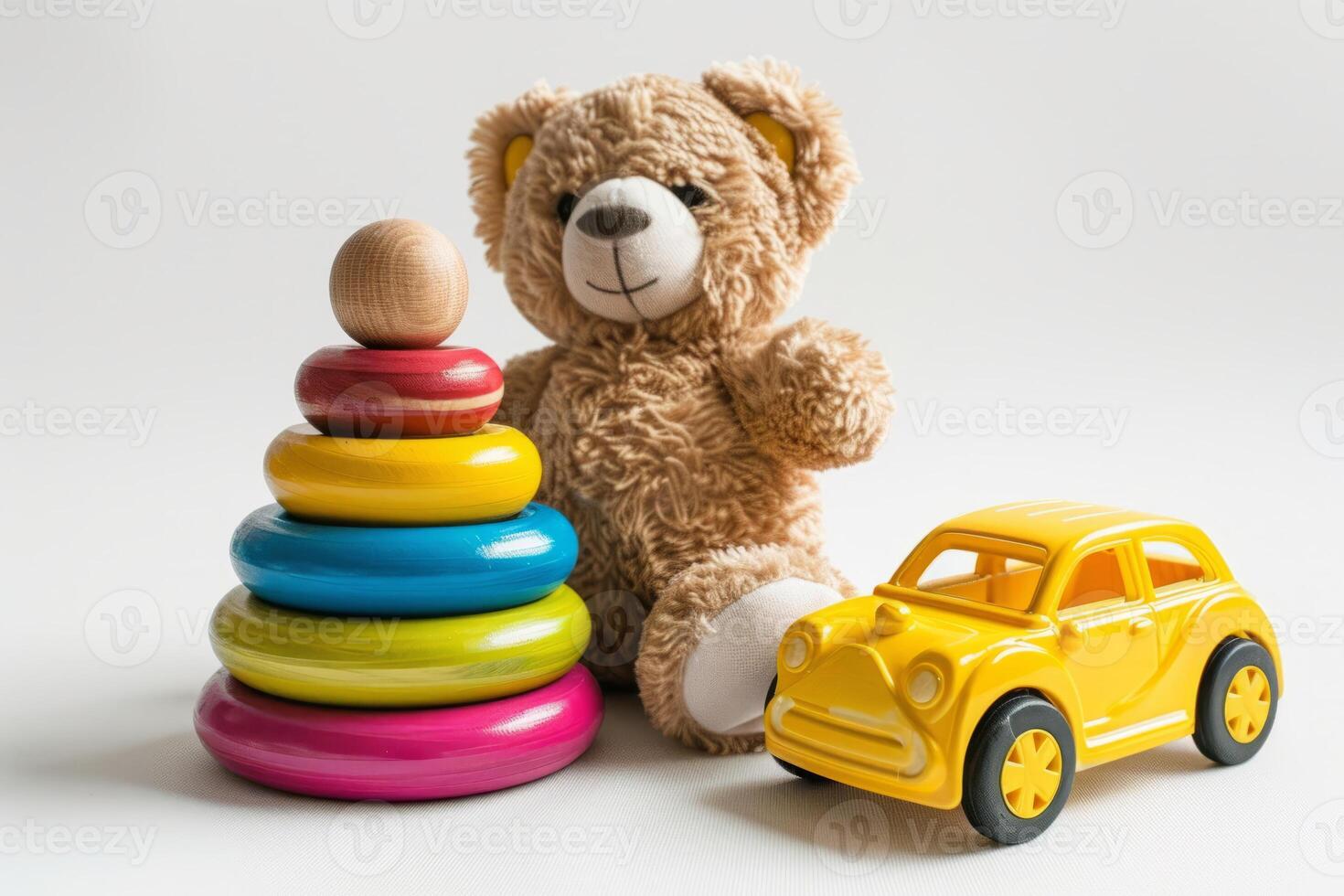 A teddy bear, a wooden pyramid with multicolored rings and a yellow car on a white background next to it. Educational toys for children. photo
