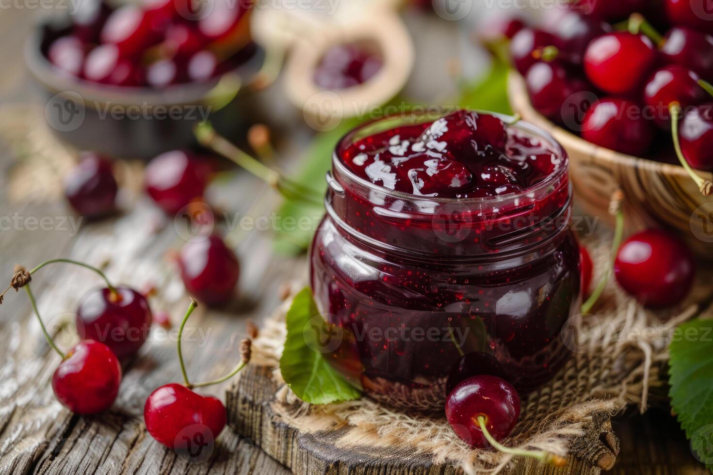 a jar of cherry jam on a wooden background. Berry jam on a wooden table. photo