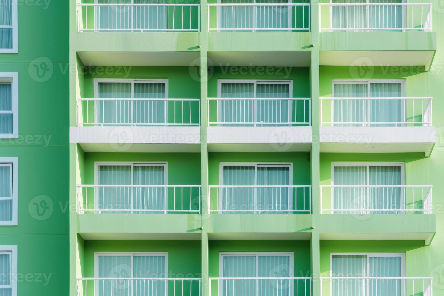 Bright green facade of old building or hotel with windows and balconies. City architecture minimalist concept. Minimal pattern building background. photo
