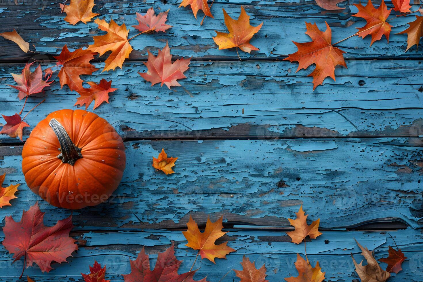 Autumn Pumpkin and Colorful Fall Leaves on Rustic Blue Wooden Background - Perfect for Harvest Themes, Thanksgiving Decor photo