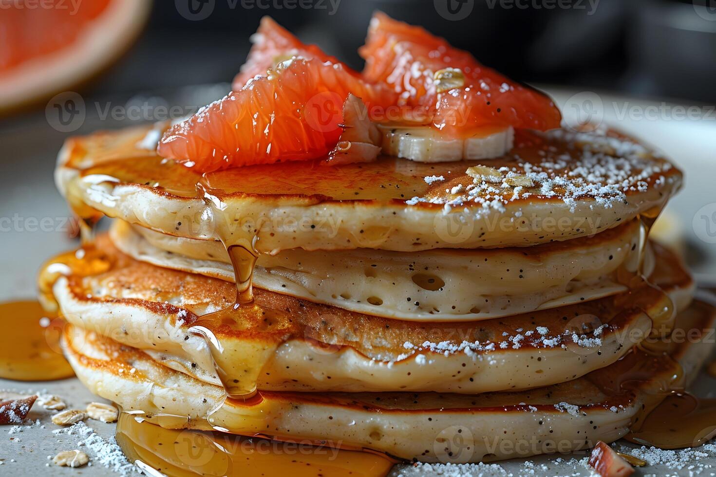 Delicious Stack of Pancakes Topped with Fresh Grapefruit Segments and Drizzled with Honey - Perfect for Breakfast photo