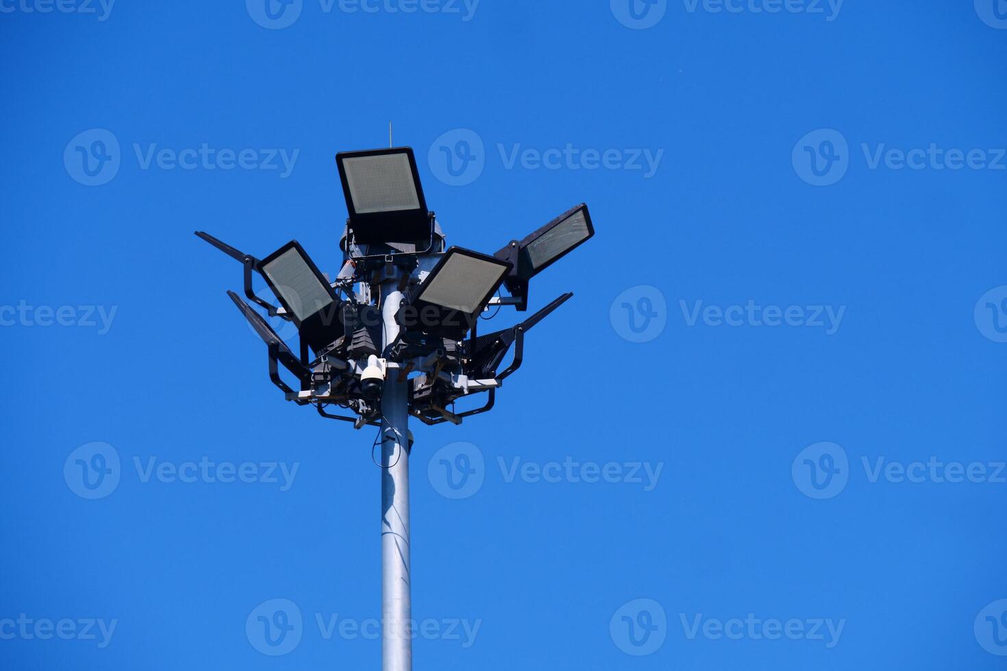 High-Powered Stadium Floodlights Against Clear Blue Sky on a Bright Sunny Day photo