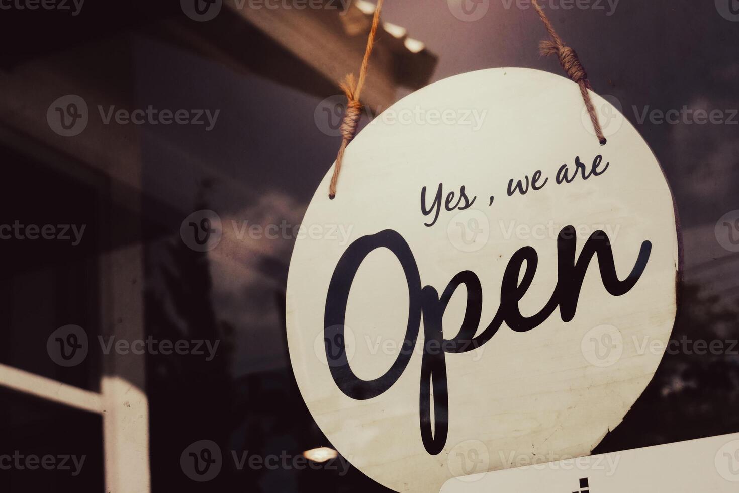 Open Sign Hanging on a Glass Door of a Small Business Shop photo