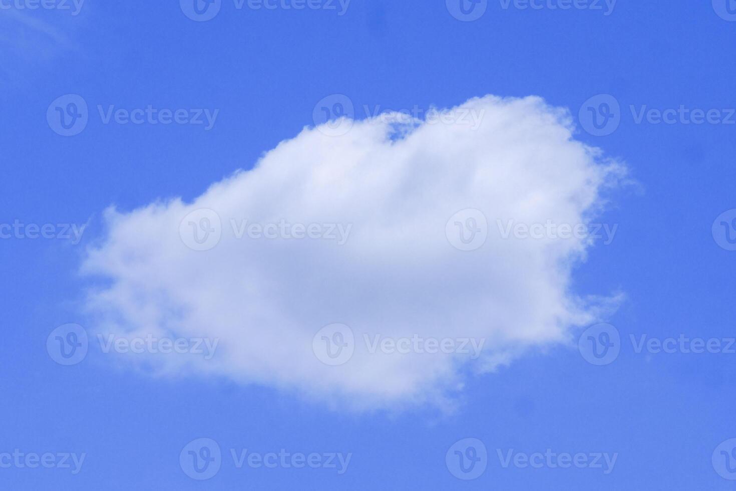Fluffy White Cloud Against a Clear Blue Sky on a Sunny Day photo