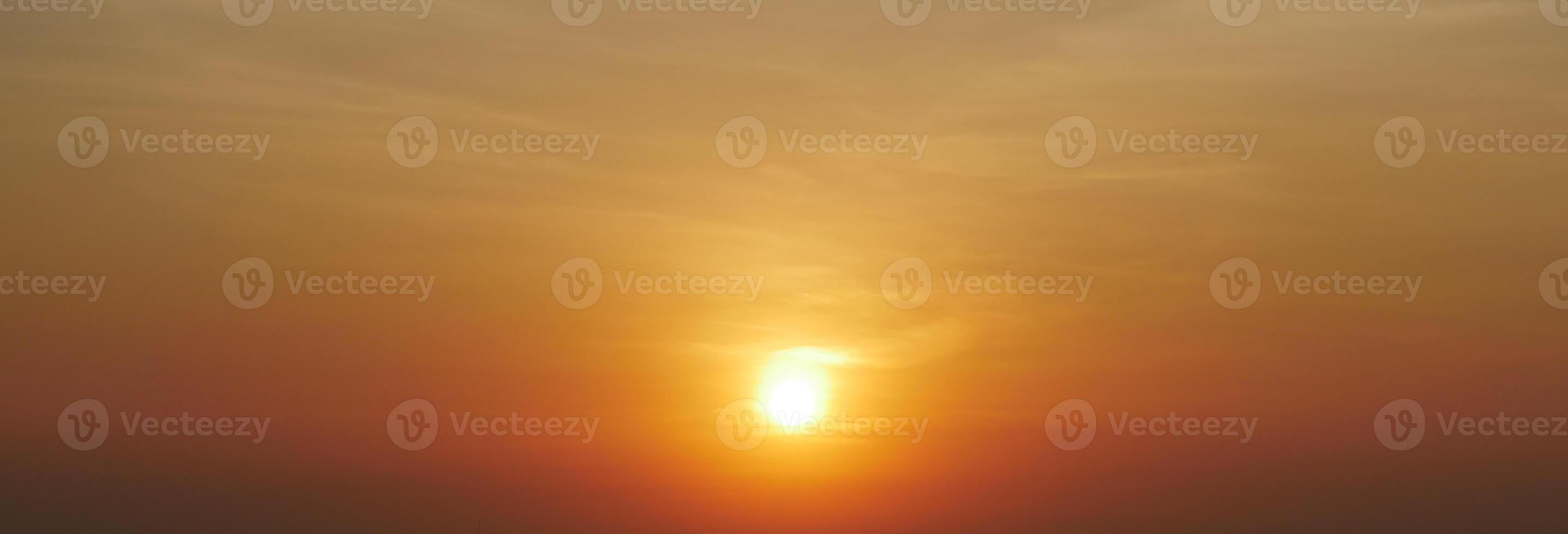 Stunning Golden Sunset with Vibrant Orange and Yellow Hues in a Clear Sky photo