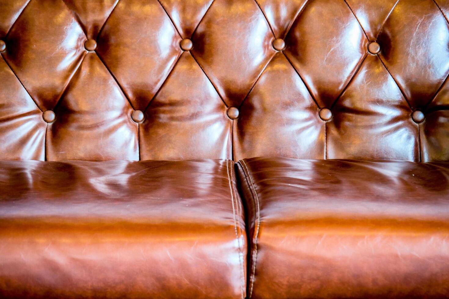 Luxurious Brown Leather Chesterfield Sofa with Button Tufting and Rich Texture in Close-Up View photo