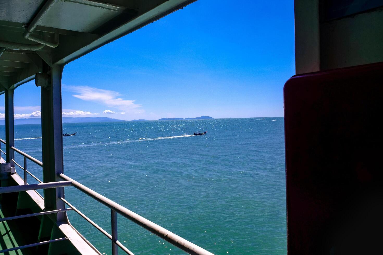 Scenic View of the Ocean from a Boat with Clear Blue Sky and Distant Islands photo