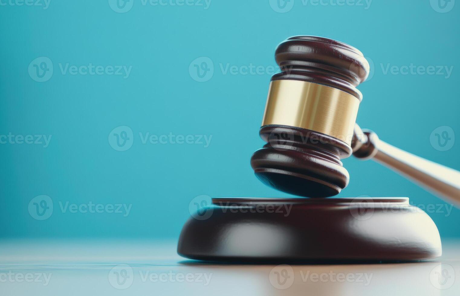 Wooden gavel on a sound block, representing justice, law, and legal proceedings, with a blue background, conceptual image. photo