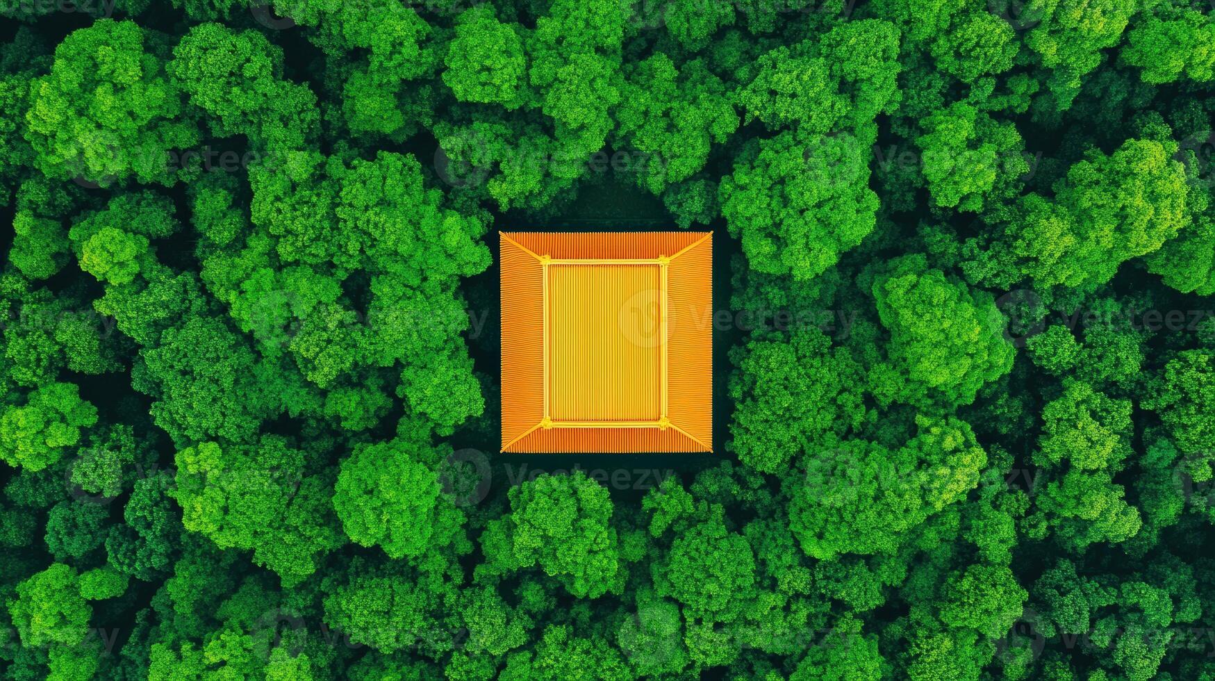 Aerial view of a vibrant yellow structure surrounded by lush green trees in a serene forest setting. photo