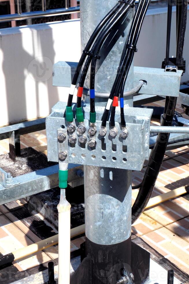 Close-up of Electrical Wiring and Connections on a Metal Pole in an Outdoor Setting photo