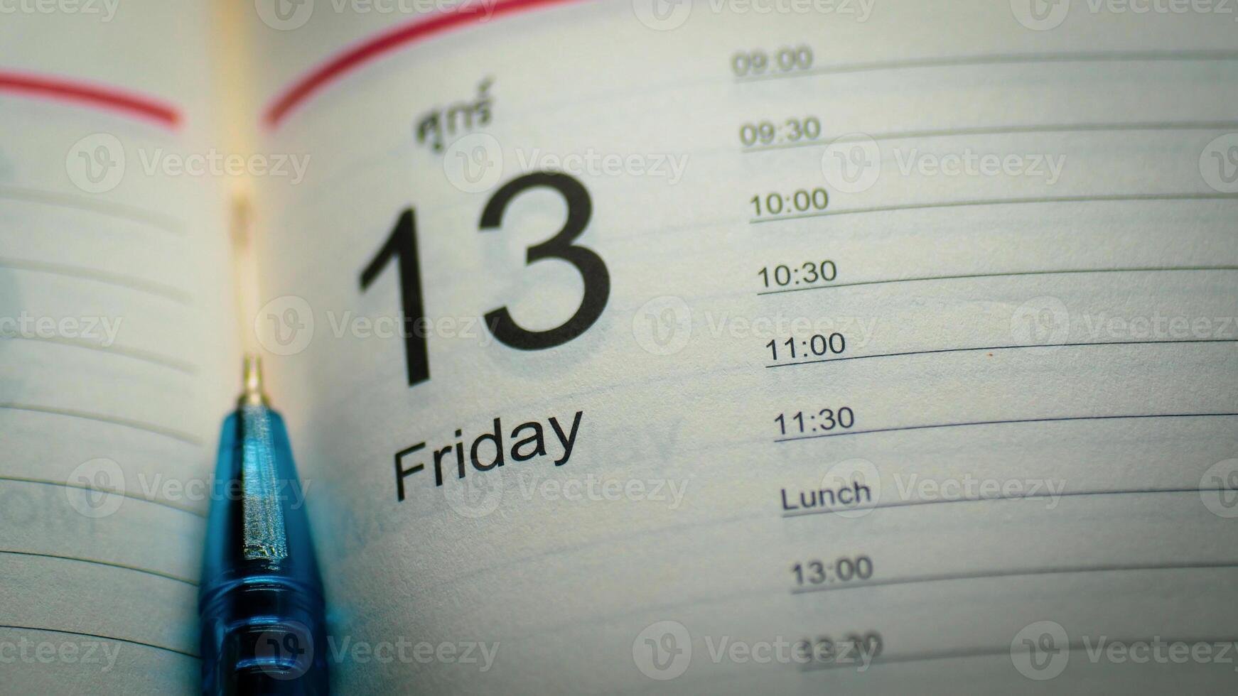 Close-Up of Calendar Showing Friday the 13th with Blue Pen on Schedule Page photo