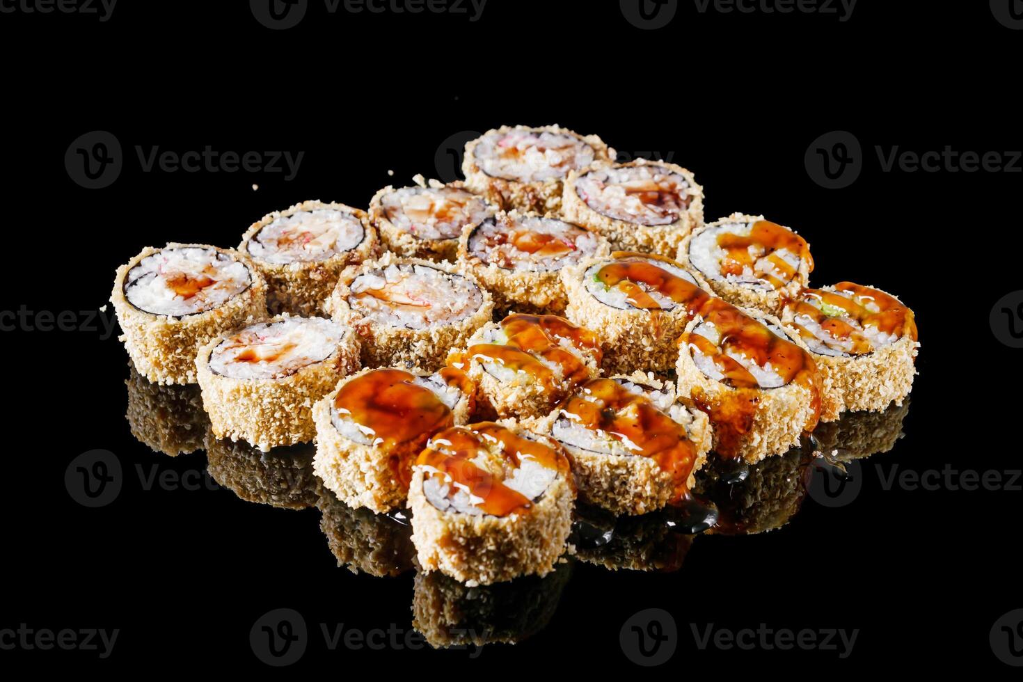 hot sushi roll tempura with eel shrimp crab salmon cream cheese cucumber avocado unagi on a black mirror background photo