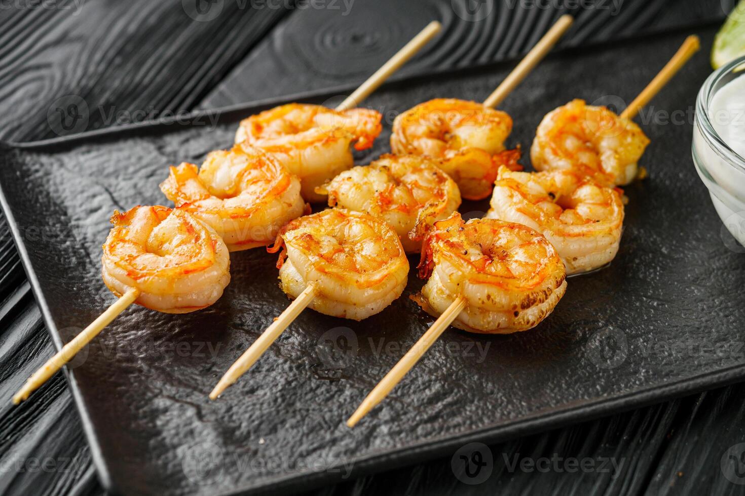delicious grilled shrimp appetizer on a black wooden rustic background photo