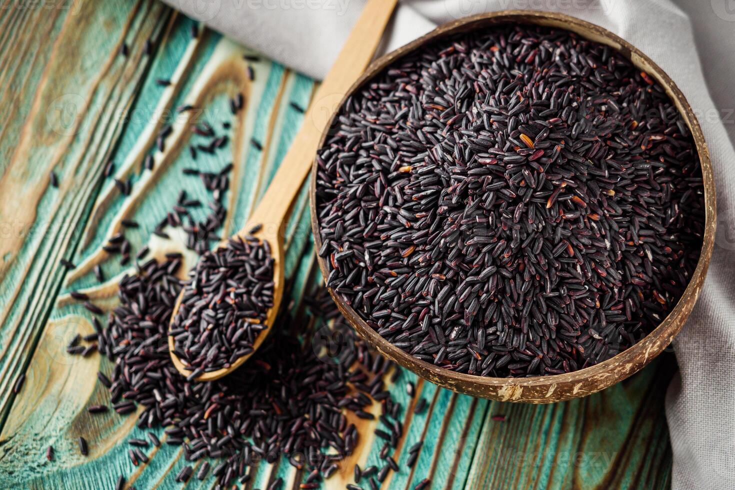 raw fresh black rice on wooden rustic background photo