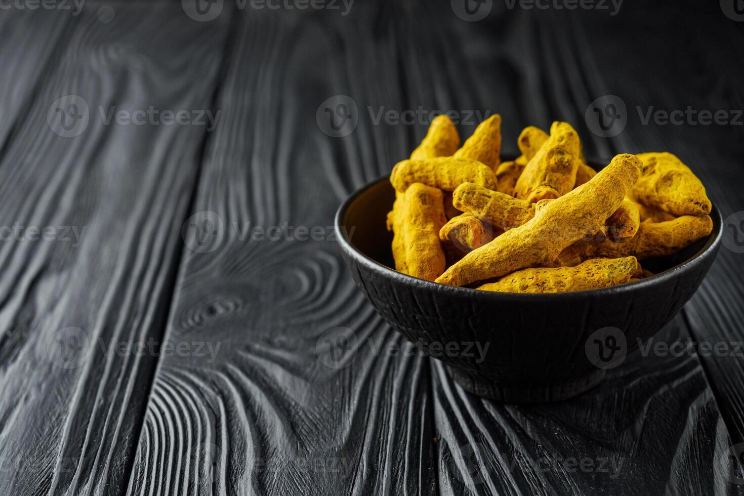 aromatic turmeric root on a black wooden rustic background photo